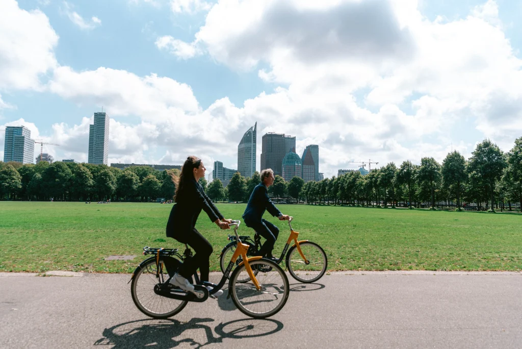 Twee werknemers van PBLQ fietsen door Den Haag